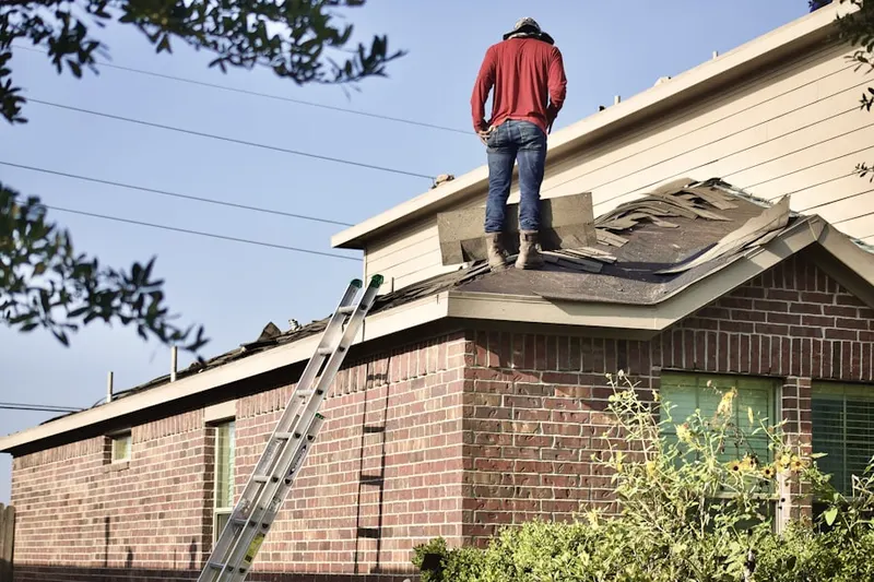 Professional roofer working on a residential roof in Penns Park